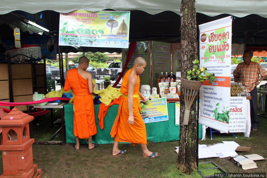 Монахи с интересом рассматривают товары на ярмарке Чиангмай, Таиланд