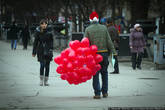 Молодые люди в шапках Санта-Клауса то ли дарили, то ли продавали девушкам воздушные шарики в виде сердечек.