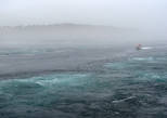 Экскурсионные моторные лодки проплывают по спокойной линии воды в середине между бурлящими водоворотами.