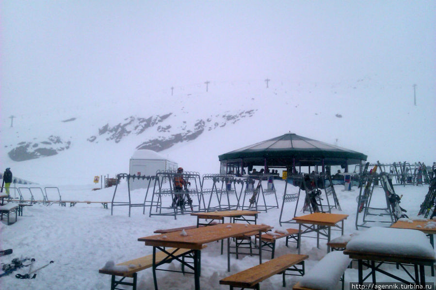 Ресторан — столики на улице засыпало снегом, за ними шатер бара Нойштифт-им-Штубайталь, Австрия