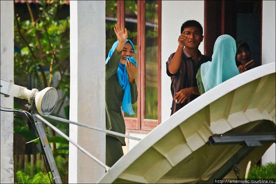 Никто не против фото — кроме мужчины, ведущего домой своих жен. Женщины, при этом, приветственно машут руками. Суматра, Индонезия