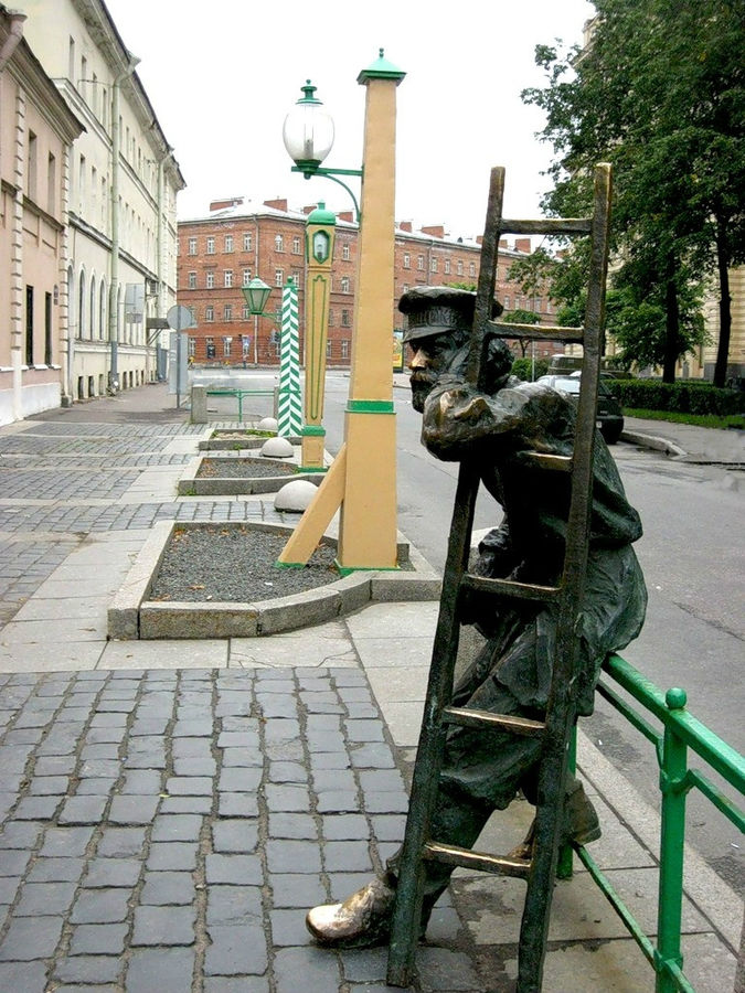 С-Пб, Одесская улица. Вид сбоку на памятник фонарщику и часть фонарей. Санкт-Петербург, Россия