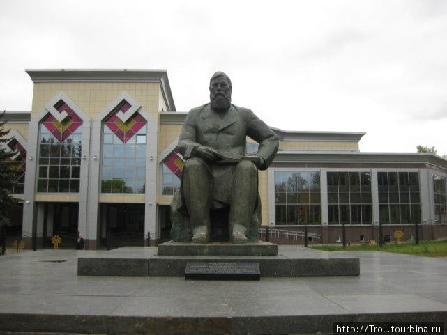 Памятник местному мастеру словесности на фоне библиотеки с национальными мотивами в архитектуре Чебоксары, Россия