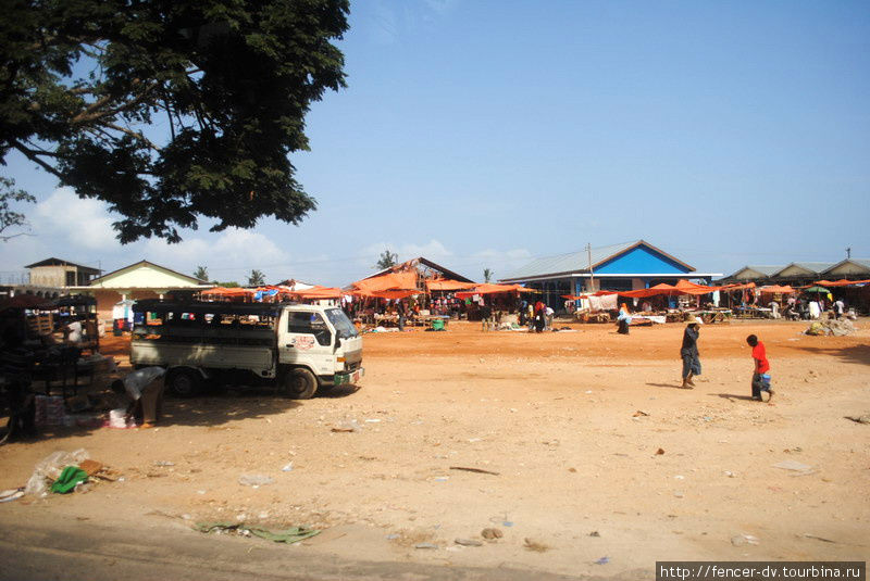 Второй по величине рынок города и одновременно автовокзал для местных маршруток со стороны выглядит как глиняный пустырь Стоун-Таун, Танзания