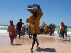 Рыбный рынок в Нуакшоте. Бригады носильщиков в ящиках на головах бегом перетаскивают рыбу из лодок на берег.