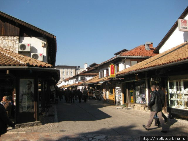 Смотрящиеся нарядными улочки с белокаменными стенами домов и красной черепицей крыш Сараево, Босния и Герцеговина