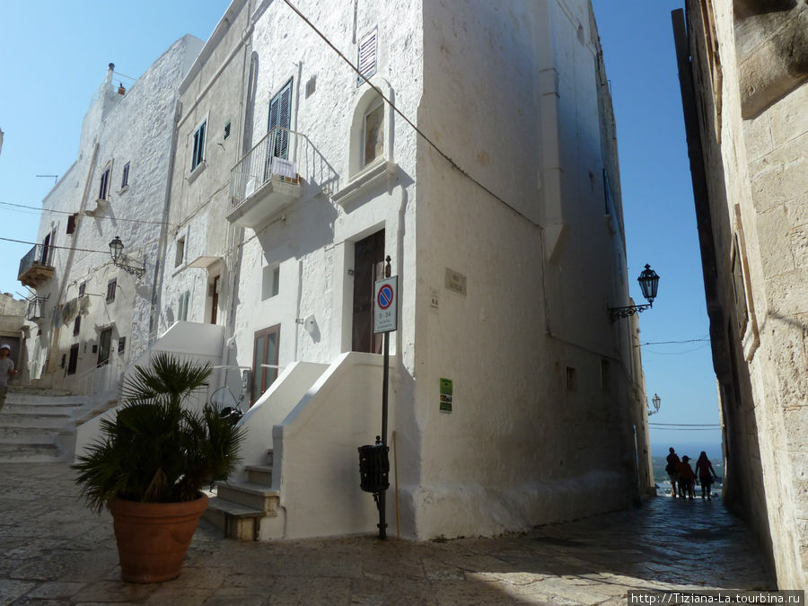 Налево вверх старинный переулок. Направо между домами смотровая площадка с видом на Адриатику. Далеко , но море видно. Остуни, Италия