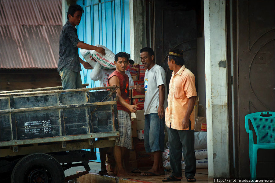 Мужчины разгружают, пожалуй, единственный на острове грузовик. Суматра, Индонезия